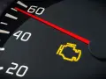Cruscotto con spia del motore lampeggiante accesa. L'ago rosso indica un valore tra 40 e 60.