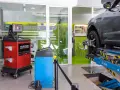 Attrezzatura per la convergenza gomme in officina. Un'auto è sollevata su un ponte, con sensori applicati alla ruota.