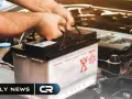 Mani che afferrano la maniglia di una batteria per auto, con i fari accesi ma la macchina spenta.