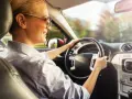 Donna sorridente guida con il volante che vibra a bassa velocità, godendosi il sole del mattino.