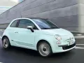 Fiat 500 azzurra in movimento, con la sua linea iconica che esprime la coppia massima di stile e agilità urbana.