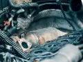 Dettaglio motore con catalizzatore, tubi e guarnizione. Si intravede un intervento di rigenerazione forzata FAP.