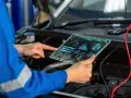 Meccanico con tablet futuristico analizza dati per il cambio centralina auto.