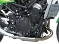 Dettaglio motore di una moto, con tubi di scarico lucidi e componenti meccanici complessi. Il freno motore è parte integrante di questo sistema.