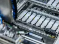 Linea di produzione per lo smaltimento batterie auto elettriche. Moduli batteria disposti su un nastro trasportatore.