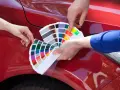 Mani scelgono colori da campionario per il costo ripristino trasparente auto.