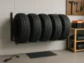 Cinque gomme per auto su un supporto a muro, un modo pratico per sapere come tenere le gomme in garage.