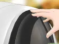 Mano che posiziona un deflettore auto, accessorio utile per migliorare il comfort di guida.