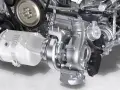 Dettaglio di un motore con un componente turbo lucido al centro, pronto a sprigionare potenza.