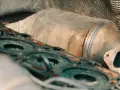 Parti del motore e un filtro antiparticolato intasato, con i rischi che comporta per le prestazioni del veicolo.