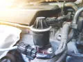 Componente egr, cos'è? Un pezzo del motore auto, con connettori elettrici e tubi.
