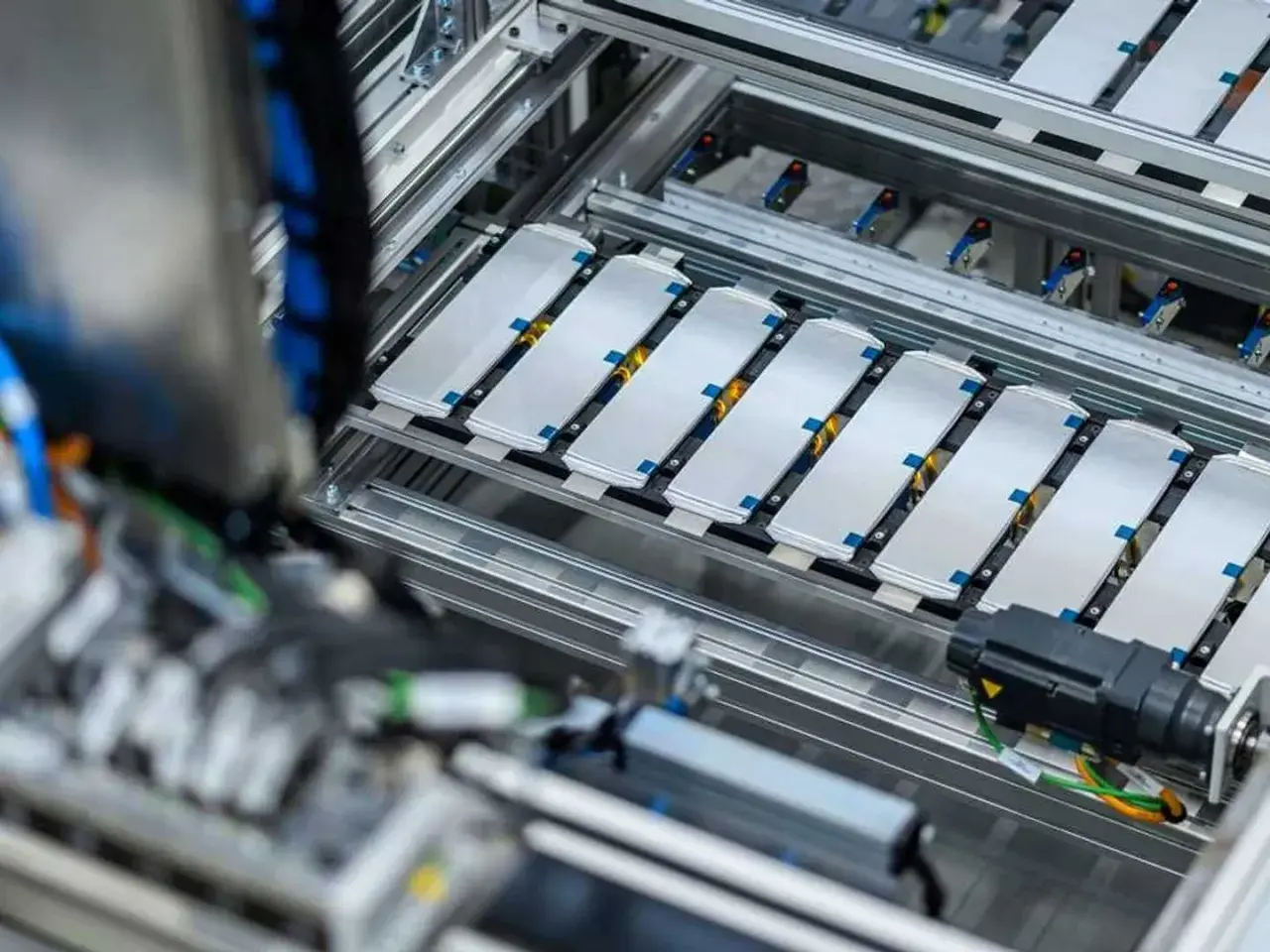 Linea di produzione per lo smaltimento batterie auto elettriche. Moduli batteria disposti su un nastro trasportatore.