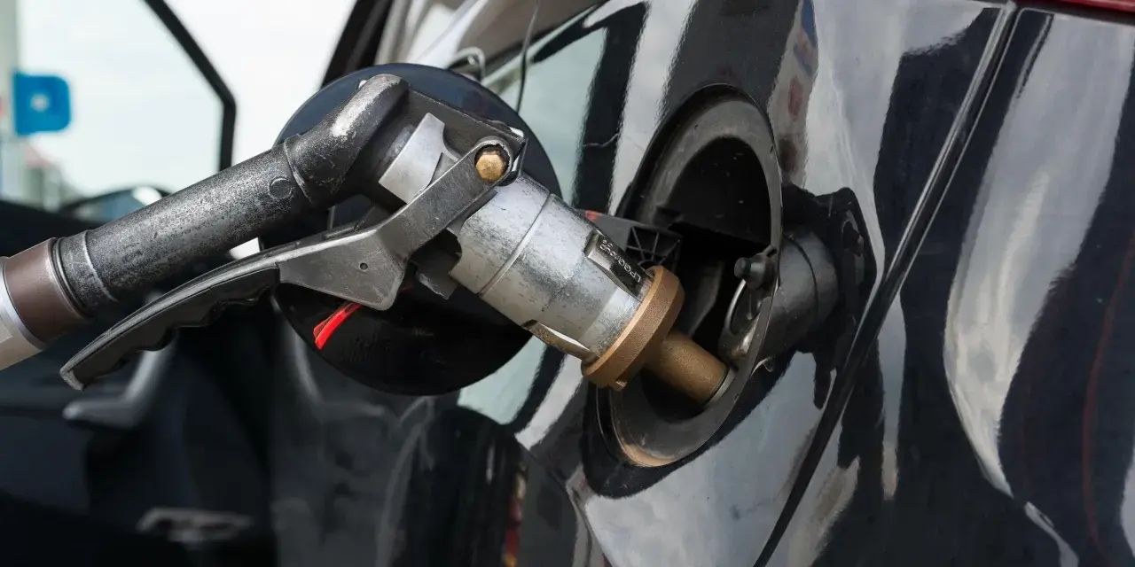 Ugello di rifornimento GPL inserito nel serbatoio di un'auto a benzina e GPL.