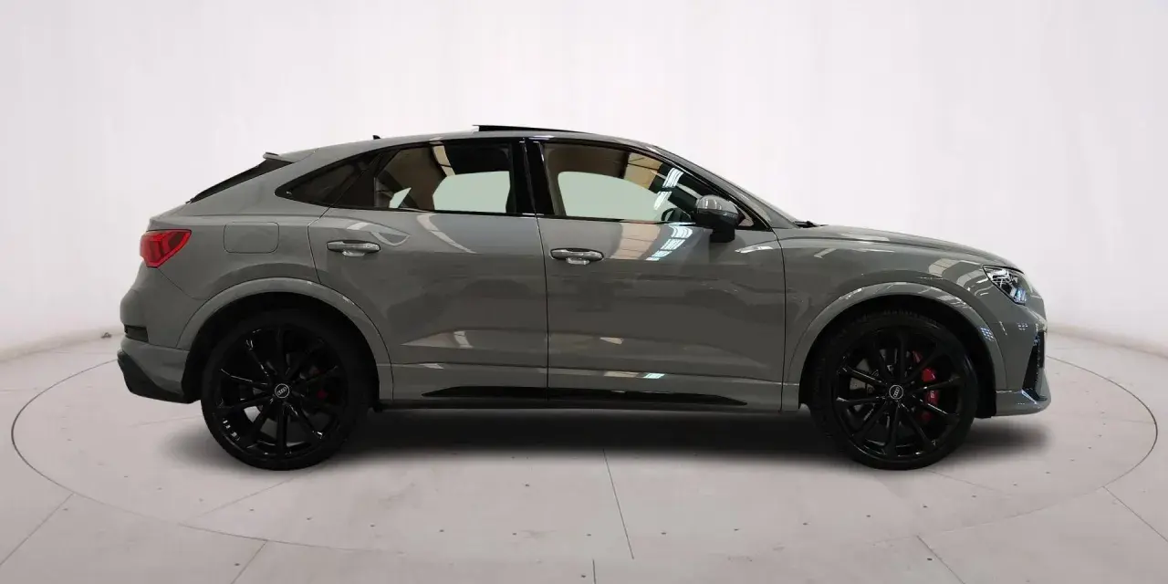 Audi RS Q3 Sportback in grigio nardo, con cerchi neri e pinze rosse. Un SUV coupé elegante e sportivo.