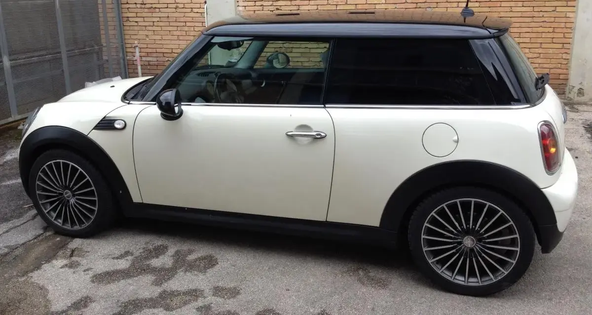 Mini Cooper bianca con tetto nero, cerchi in lega. Il codice colore si trova solitamente su un'etichetta nel vano motore o nel montante della portiera.