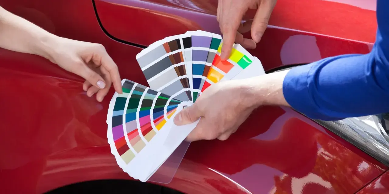 Mani scelgono colori da campionario per il costo ripristino trasparente auto.