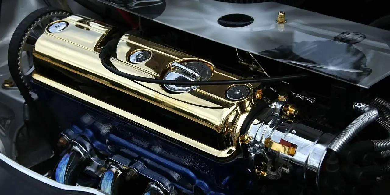 Motore cromato e dorato con puleggia visibile. La puleggia del motore è un componente essenziale per la trasmissione di potenza.