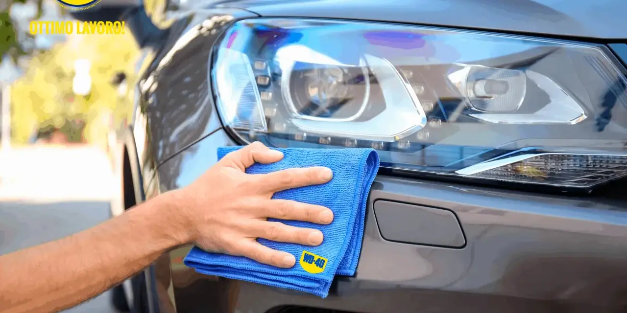 Mano che lucida fari auto con WD-40 e panno blu. Ottimo lavoro!