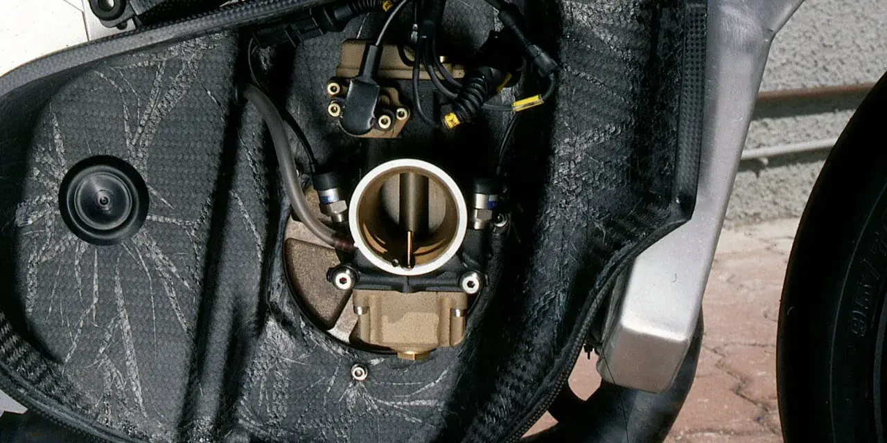 Dettaglio del corpo farfallato di una moto, parte essenziale per la corretta miscela grassa del motore.
