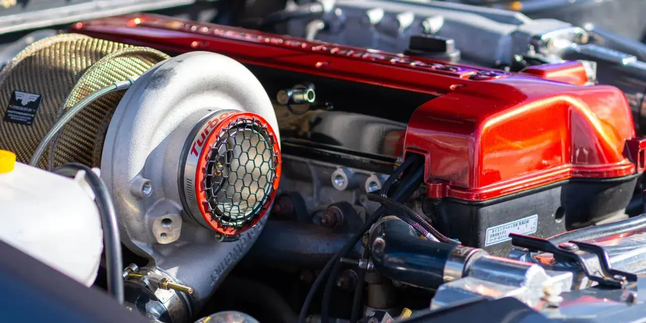 Motore con turbocompressore cromato e coperchio valvole rosso lucido. La differenza tra motore aspirato e turbo è evidente in questa immagine.