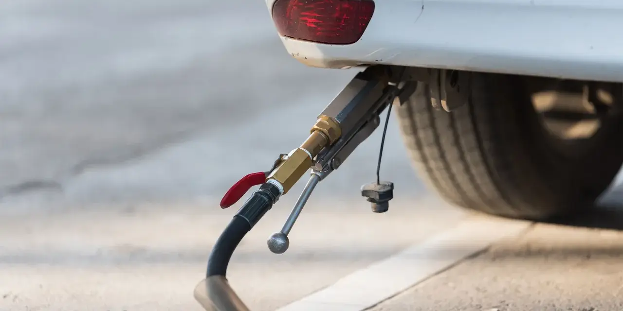 Rifornimento di un'auto a gas. Il tubo di erogazione è collegato all'attacco, pronto per il pieno. GPL e metano sono la stessa cosa per molti, ma non è così.