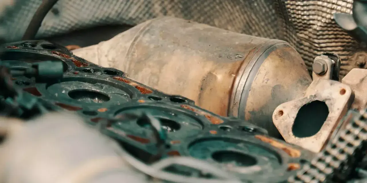 Parti del motore e un filtro antiparticolato intasato, con i rischi che comporta per le prestazioni del veicolo.