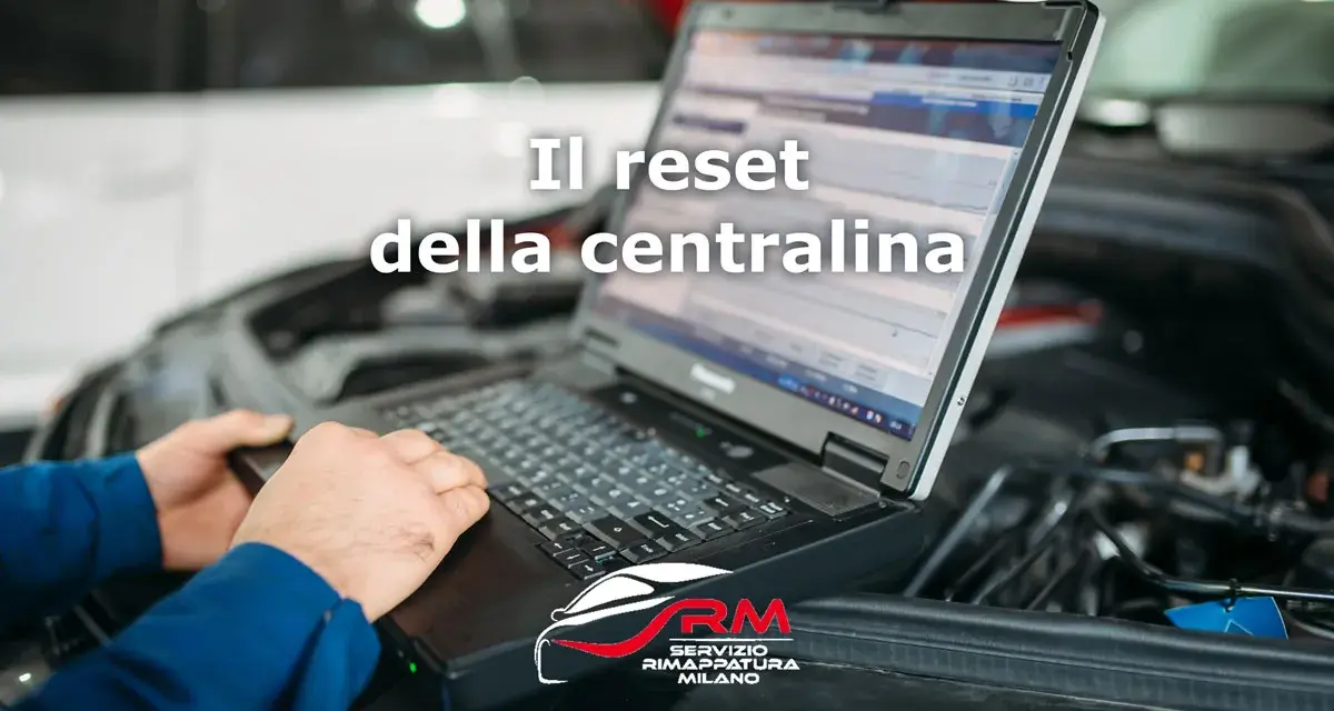 Tecnico esegue il reset centralina auto con laptop. Il logo RM Servizio Rimappatura Milano è visibile.
