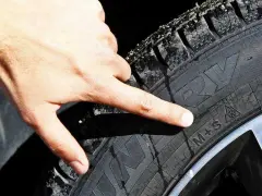 Dito il simbolo M+S su un pneumatico, indicativo dell'obbligo gomme da neve.