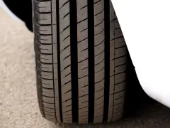 Primo piano del battistrada gomme di un'auto bianca, con solchi profondi per una presa ottimale sull'asfalto.