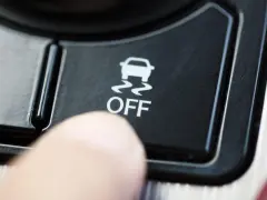 Dito, un dito preme il pulsante "OFF" del sistema di controllo stabilità della macchina, disattivandolo.