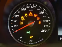 Cruscotto auto con spie gialle accese: controllo stabilità, motore, airbag, cinture. La lancetta segna circa 20 km/h.