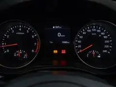 Cruscotto auto con tachimetro, contagiri e spia freno a mano accesa.