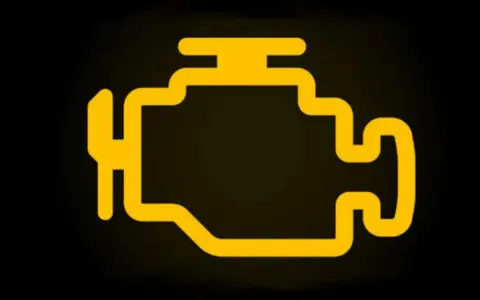 Spia motore accesa ma la macchina va bene. Icona gialla stilizzata di un motore su sfondo nero.