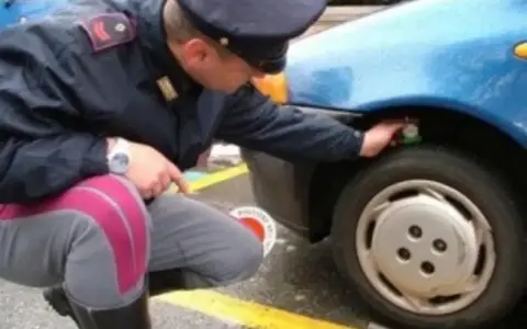 Agente controlla gomme diverse su 4x4, forse per un controllo di routine o per una multa.