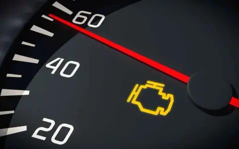 Cruscotto con spia del motore lampeggiante accesa. L'ago rosso indica un valore tra 40 e 60.
