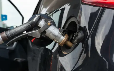 Ugello di rifornimento GPL inserito nel serbatoio di un'auto a benzina e GPL.