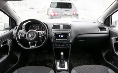 Interno di una Volkswagen Polo, con volante, cruscotto e cambio. Il display mostra il parcheggio assistito, utile per chi cerca il codice colore auto Volkswagen Polo.