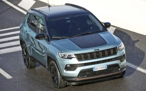 Jeep Compass color acqua con tetto nero, su strada con strisce bianche. La pressione pneumatici è ottimale per affrontare ogni percorso.