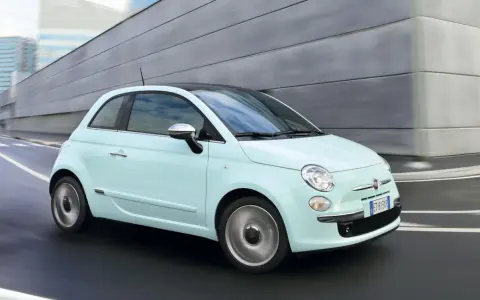 Fiat 500 azzurra in movimento, con la sua linea iconica che esprime la coppia massima di stile e agilità urbana.