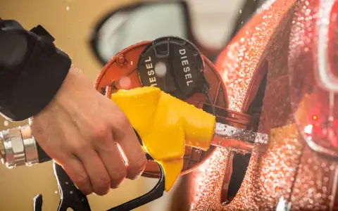 Mano che inserisce la pompa diesel. Cosa succede se metti benzina nel diesel? Dopo quanti km si notano i danni?