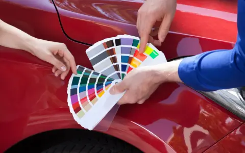 Mani scelgono colori da campionario per il costo ripristino trasparente auto.
