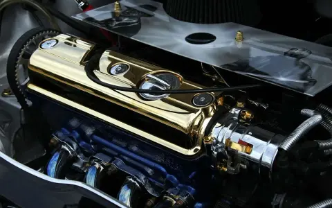 Motore cromato e dorato con puleggia visibile. La puleggia del motore è un componente essenziale per la trasmissione di potenza.