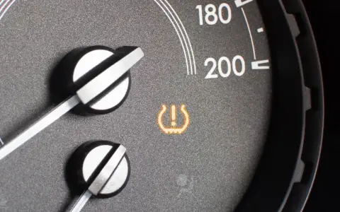 Spia del sistema TPMS accesa sul cruscotto, indica un problema di pressione pneumatici.
