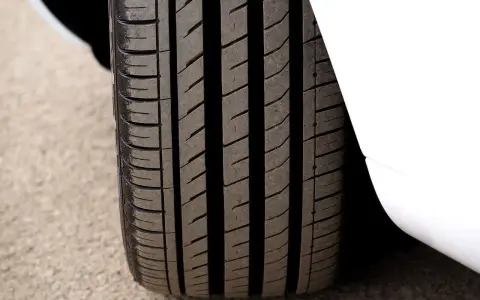 Primo piano del battistrada gomme di un'auto bianca, con solchi profondi per una presa ottimale sull'asfalto.