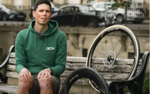 Ciclista con due ruote da bici, una più grande per maggiore velocità.