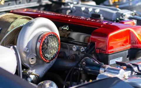 Motore con turbocompressore cromato e coperchio valvole rosso lucido. La differenza tra motore aspirato e turbo è evidente in questa immagine.
