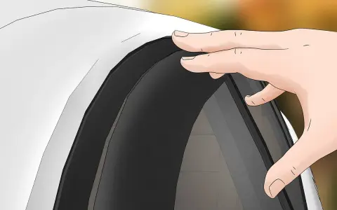 Mano che posiziona un deflettore auto, accessorio utile per migliorare il comfort di guida.