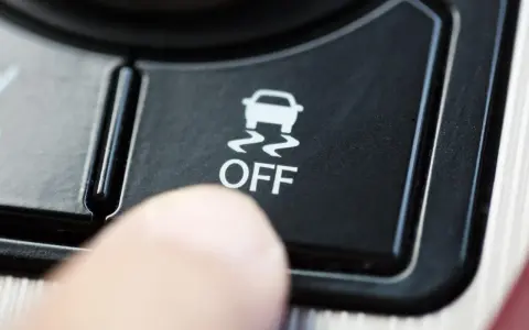 Dito, un dito preme il pulsante "OFF" del sistema di controllo stabilità della macchina, disattivandolo.