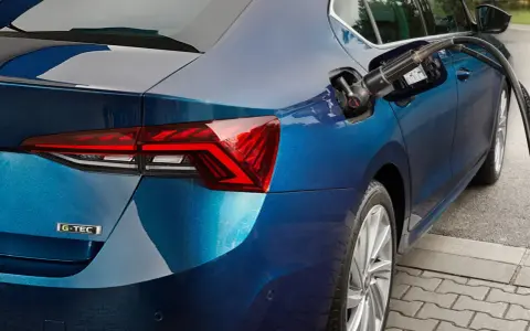 Rifornimento di un'auto blu con motore a metano. La pompa è inserita nel serbatoio.