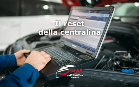 Tecnico esegue il reset centralina auto con laptop. Il logo RM Servizio Rimappatura Milano è visibile.